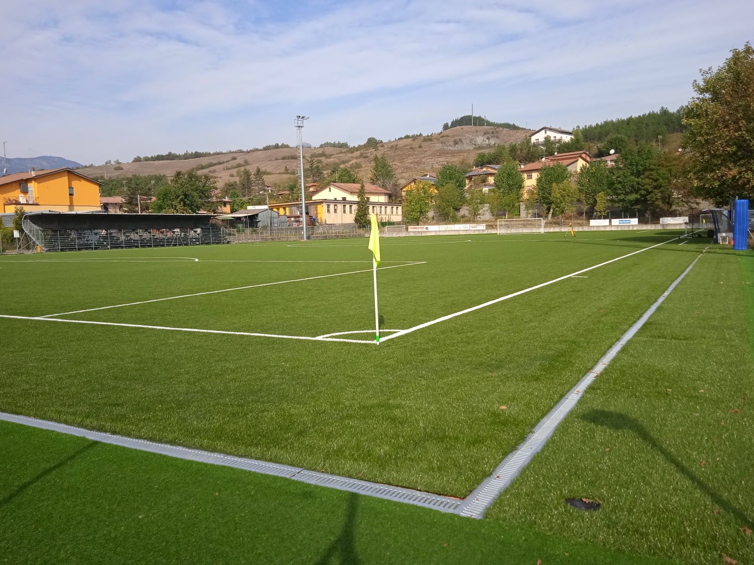 Campo sportivo Adelmo Adalberti a Firenzuola (FI) con erba sintetica, realizzato per garantire prestazioni ottimali. Questo impianto sportivo in Toscana beneficia di una manutenzione accurata, inclusa la spazzolatura e il controllo dell'intasamento per preservare la qualità del campo da calcio. L'erba sintetica installata riduce la manutenzione complessiva e offre una superficie di gioco uniforme e sicura, ideale per tutte le stagioni. Il campo è progettato per resistere all'uso intensivo, mantenendo elevati standard di prestazione.