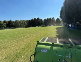 Vista ravvicinata dell’intervento di arieggiatura meccanica sul campo in erba naturale presso il centro sportivo Inter Club Parma, fase cruciale per il miglioramento della struttura del suolo e la rigenerazione radicale del manto erboso.