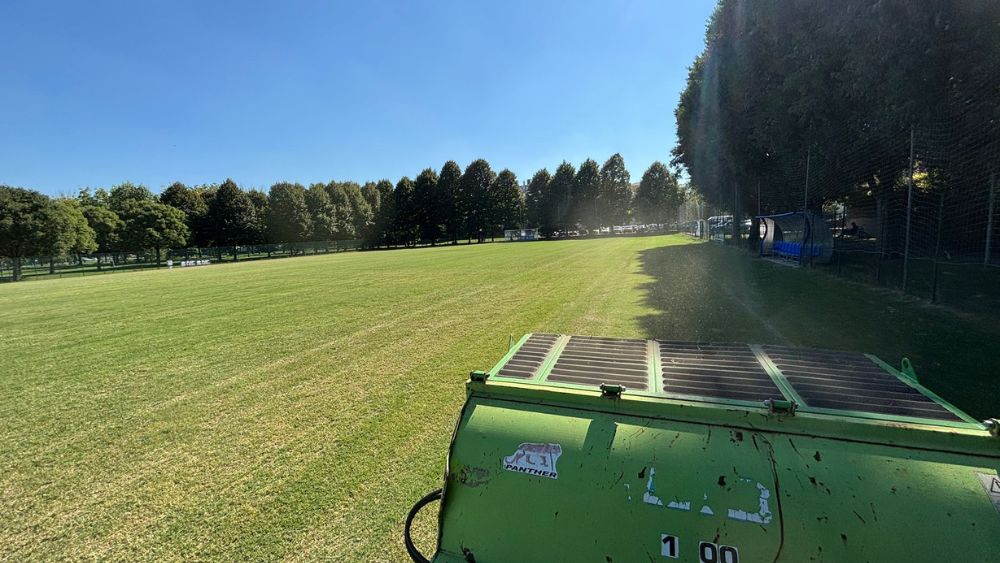 Vista ravvicinata dell’intervento di arieggiatura meccanica sul campo in erba naturale presso il centro sportivo Inter Club Parma, fase cruciale per il miglioramento della struttura del suolo e la rigenerazione radicale del manto erboso.